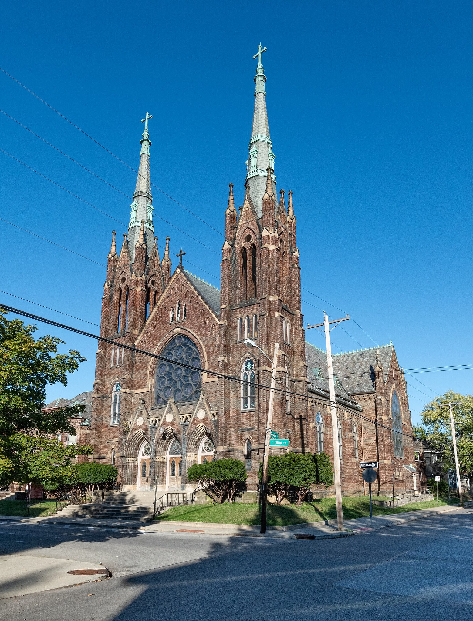 Exterior view of St. John the Evangelist Catholic Church with twin Gothic spires, vitrified brick facade, and rose window at South Ohio Avenue and Newton Street in Columbus, Ohio.