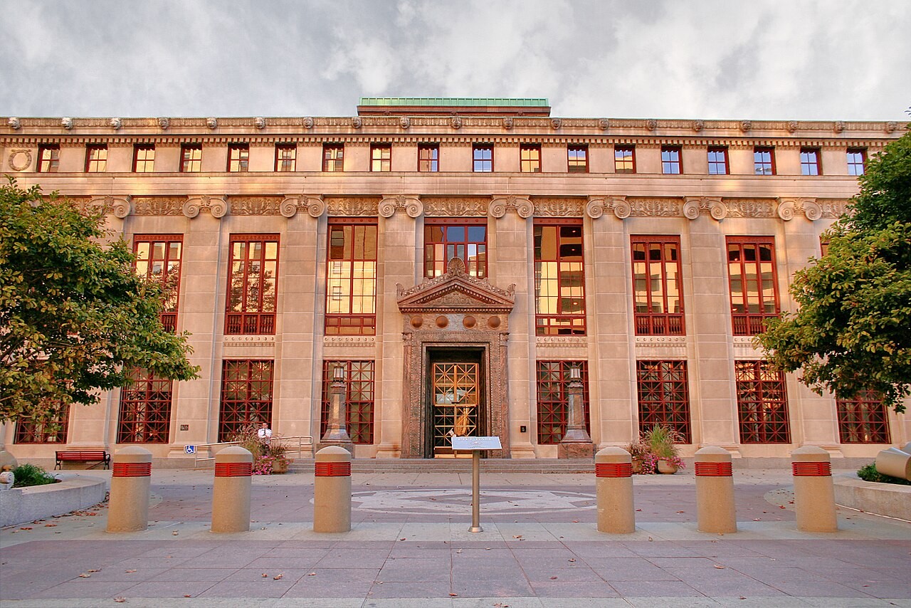 Frontal view of Columbus City Hall exterior facade featuring classical pilasters, multi-pane windows, and central entryway.
