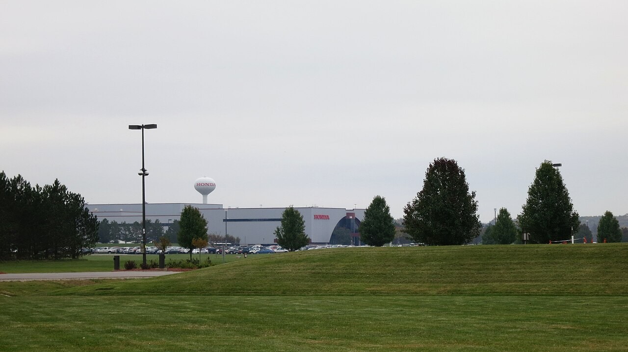 Exterior view of the Honda East Liberty Auto Plant with a white water tower bearing the red Honda logo in Union County, Ohio.