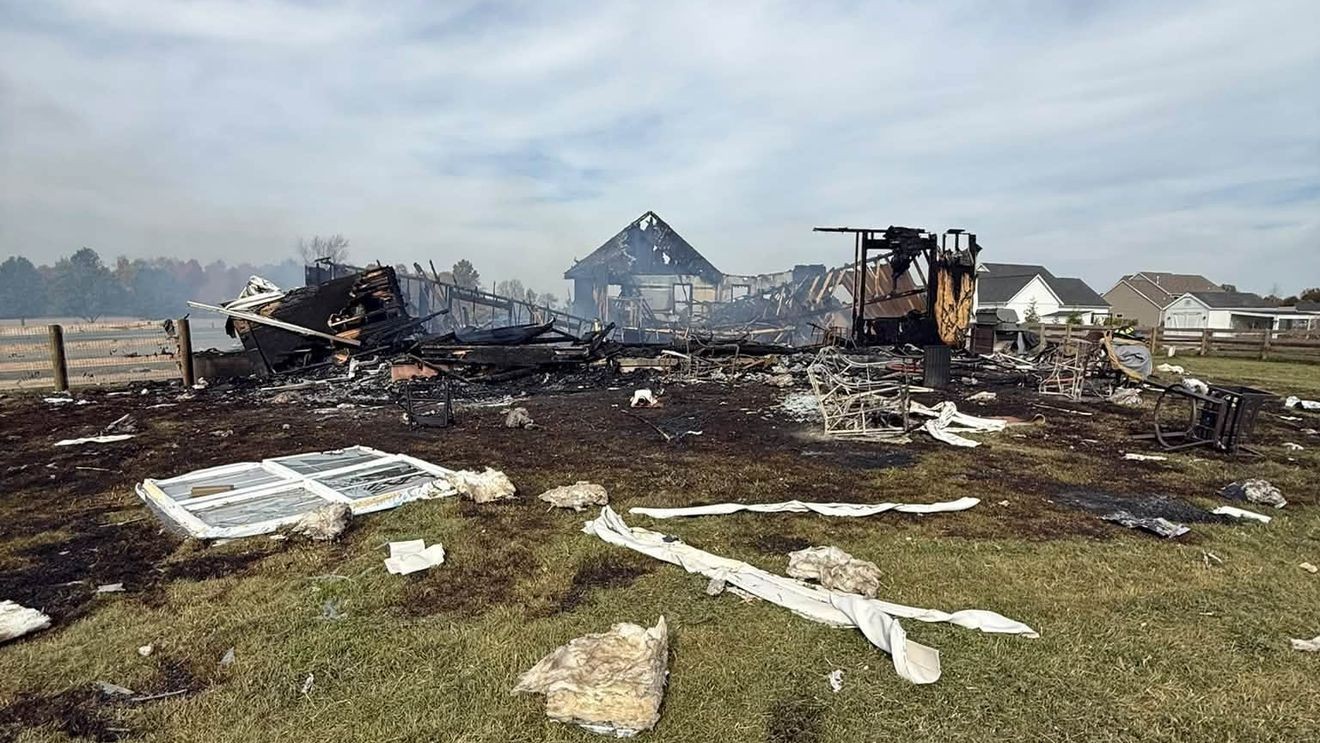 Charred rubble and scattered debris of a destroyed home on Evans Road in Harlem Township.
