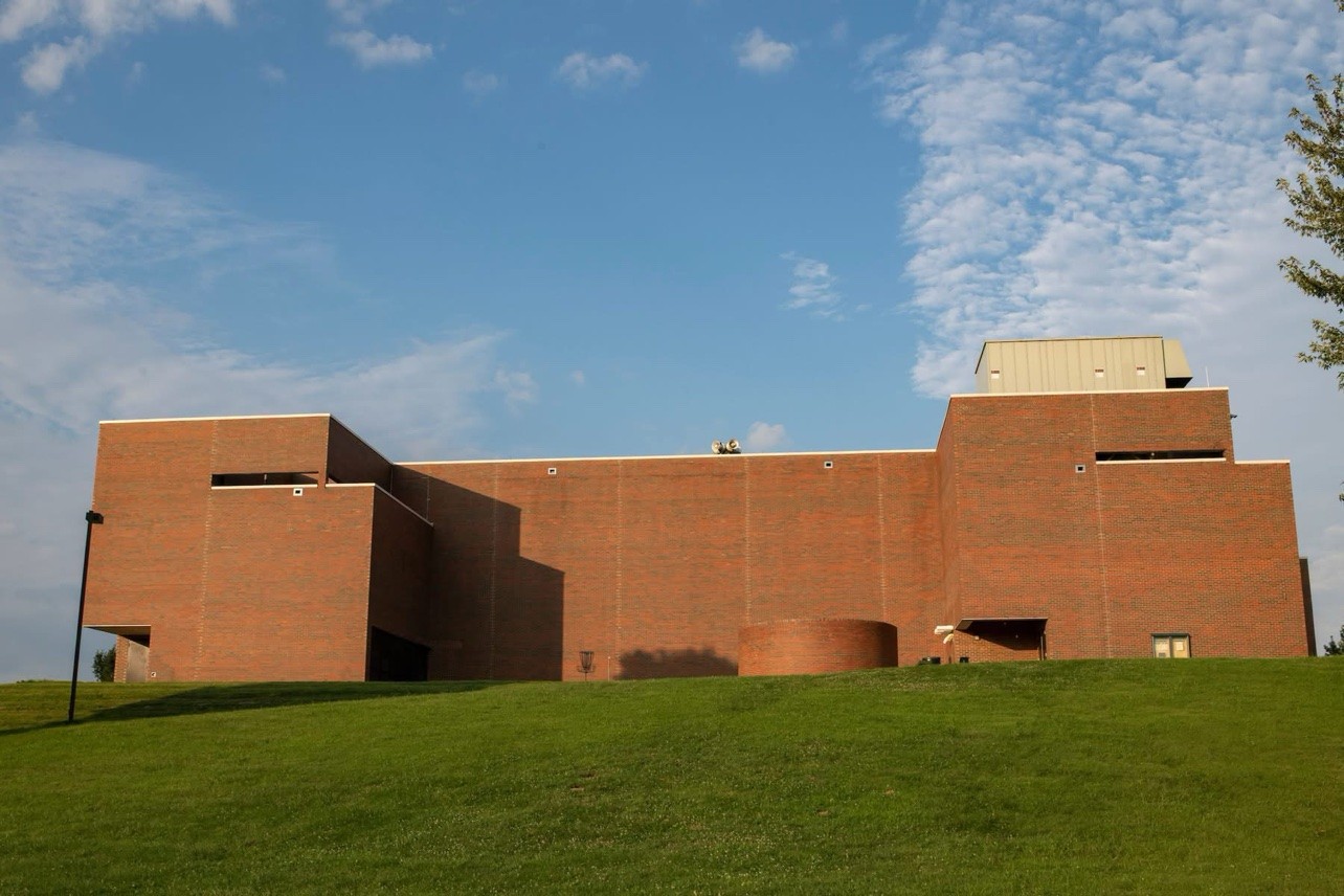 Exterior view of the red brick Shoemaker Center on a grassy hill under a blue sky at Ohio University Chillicothe.