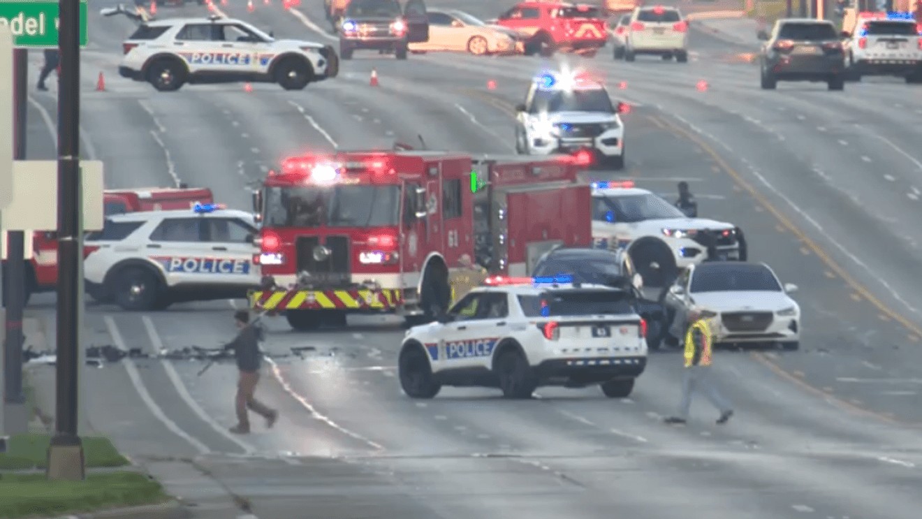 Columbus Police vehicles and a Columbus Fire truck block lanes on Morse Road as emergency responders handle a crash scene.