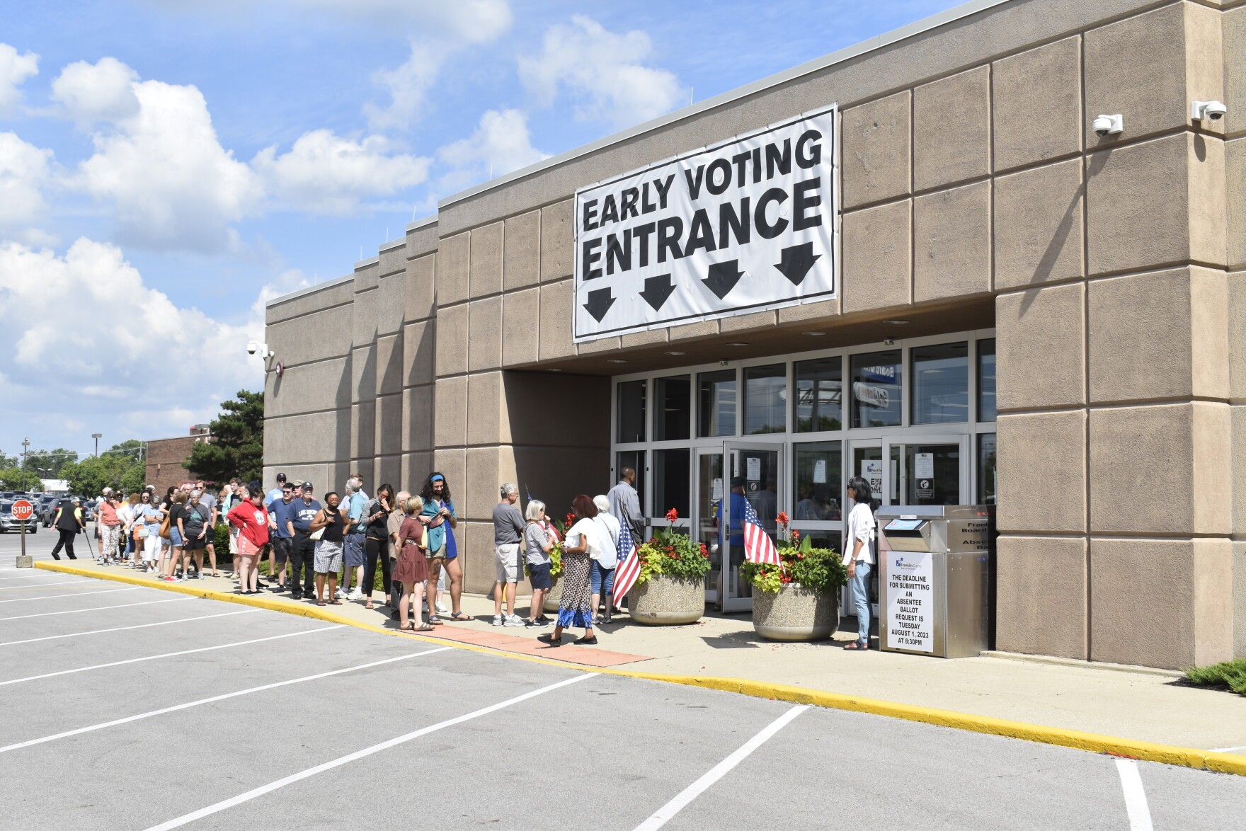 A long queue of voters waiting on the sidewalk outside the Franklin County Early Voting entrance under a banner reading Early Voting Entrance.